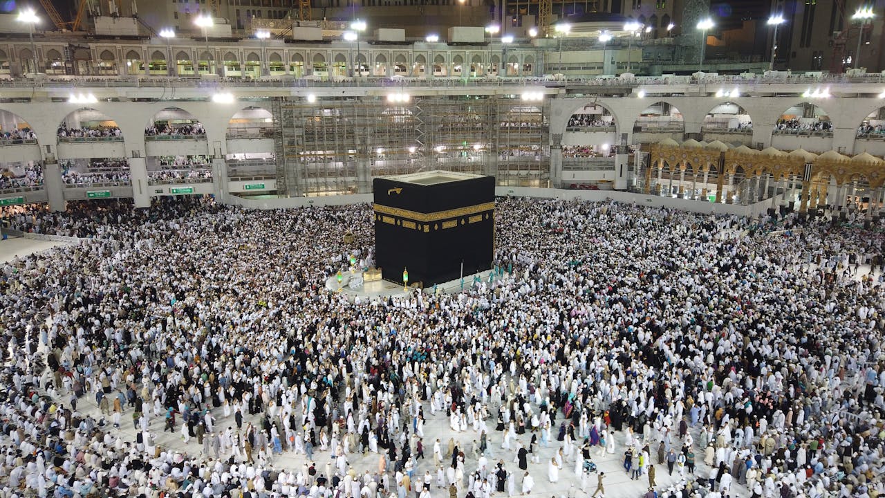 Aerial view of thousands of pilgrims gathered around the Kaaba at night in Mecca, Saudi Arabia.